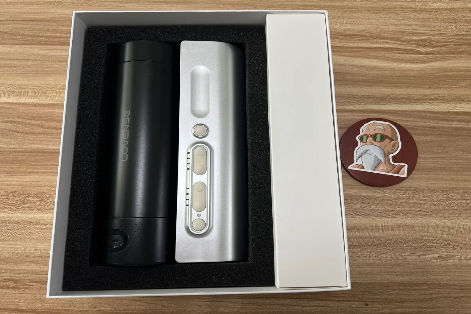 Déballage du Lovense Solace Pro, avec l'appareil protégé par une mousse noire et une boîte d'accessoires à droite