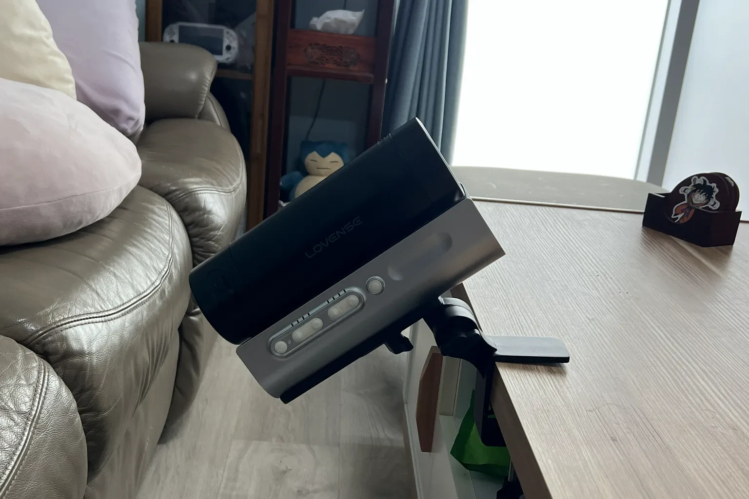 Lovense Solace Pro fixé au bord d'une table avec son support fourni, montrant l'appareil incliné grâce au réglage de l'angle